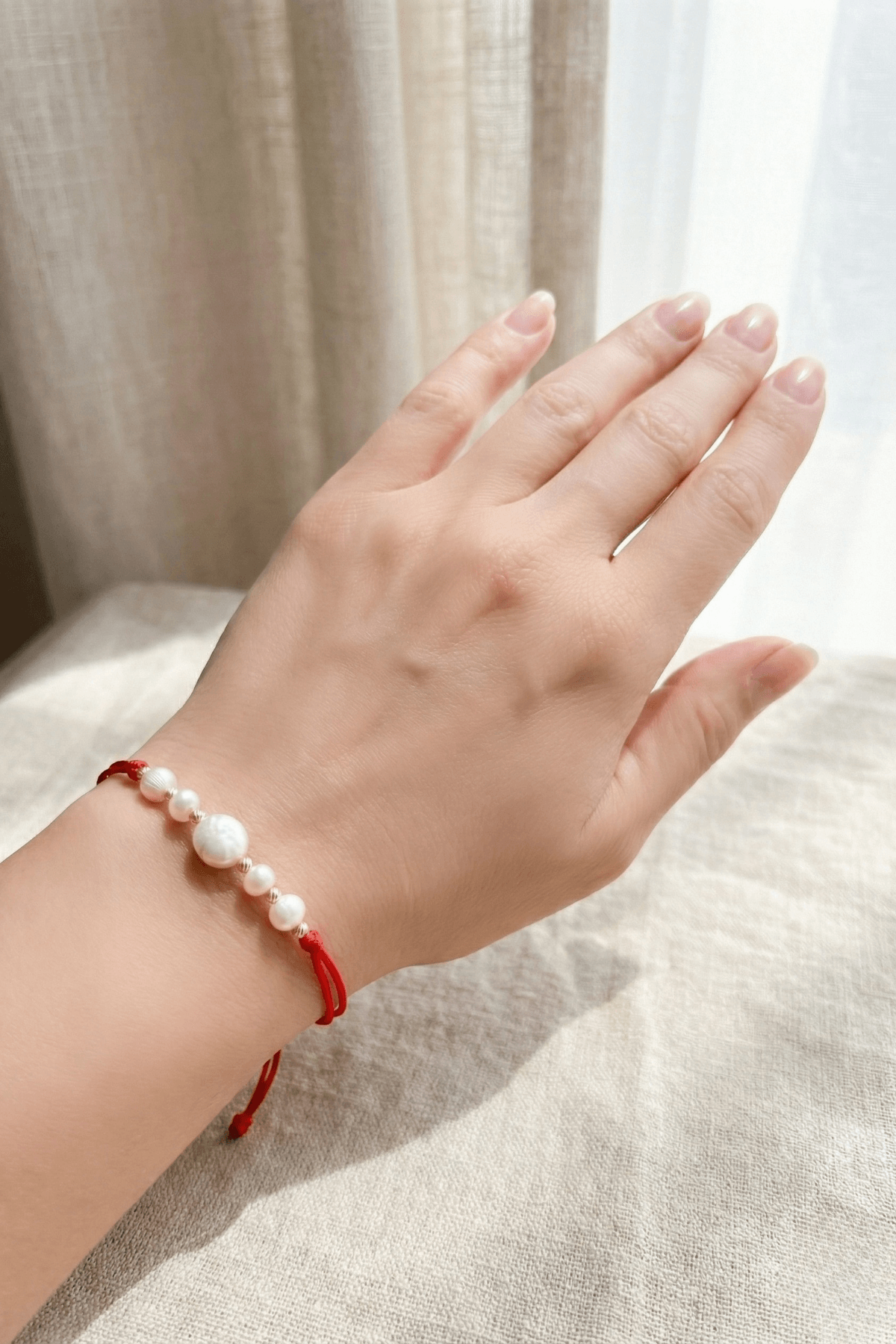 Kırmızı doğal inci şans bilekliği, el üzerinde zarif bir şekilde duruyor, İnci Bileklik.