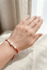 Kırmızı doğal inci şans bilekliği, el üzerinde zarif bir şekilde duruyor, İnci Bileklik.