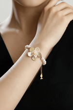 Doğal inci çiçek bileklik, şık tasarımlı ve zarif görüntüye sahip, el bileğinde takılı.