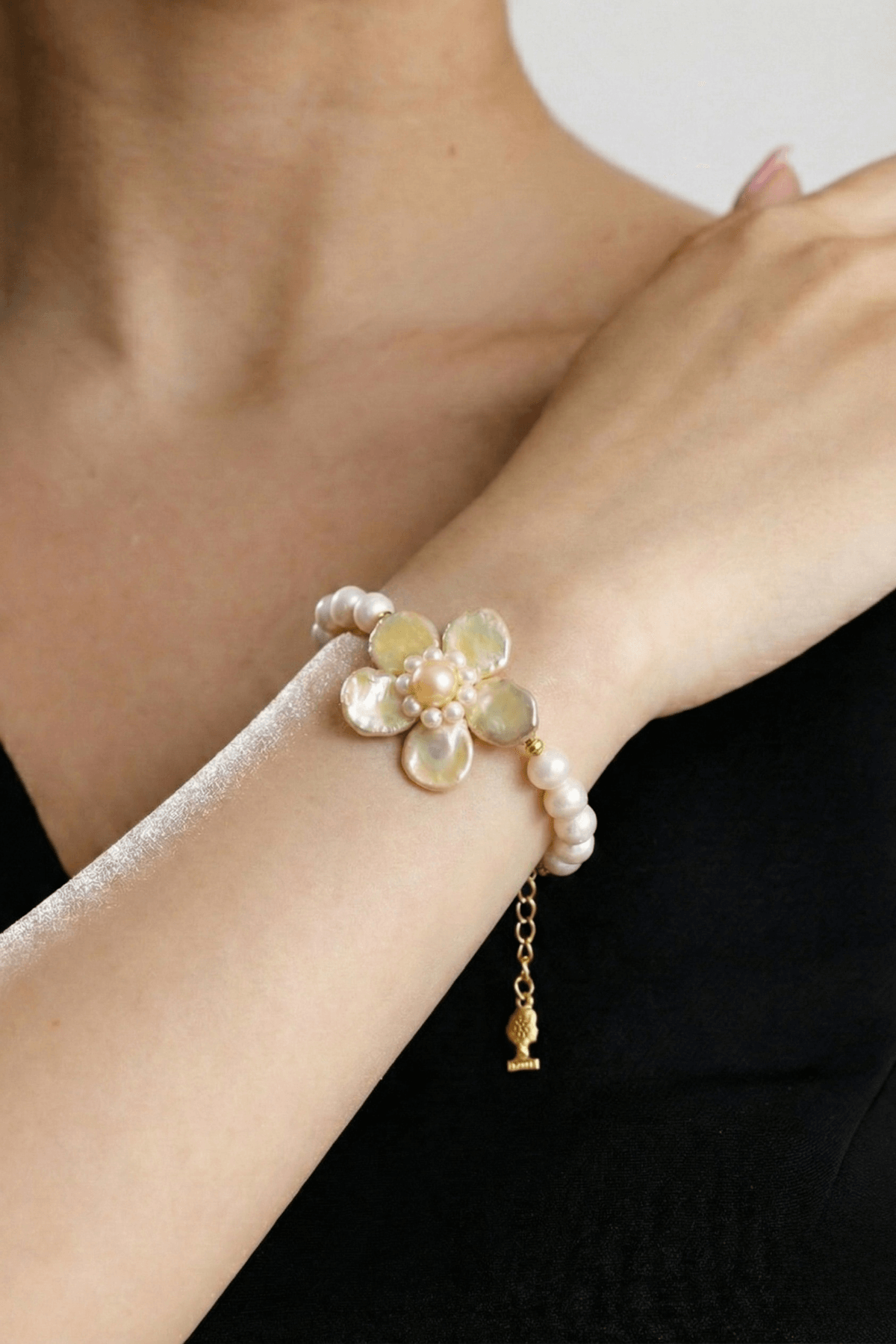 Doğal inci çiçek bileklik, zarif inci detaylarıyla süslü, el bileğinde şık bir görünüm sunuyor.