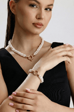 Doğal inci burgu bileklik ve inci kolye takan kadın modeli, şık görünüm.