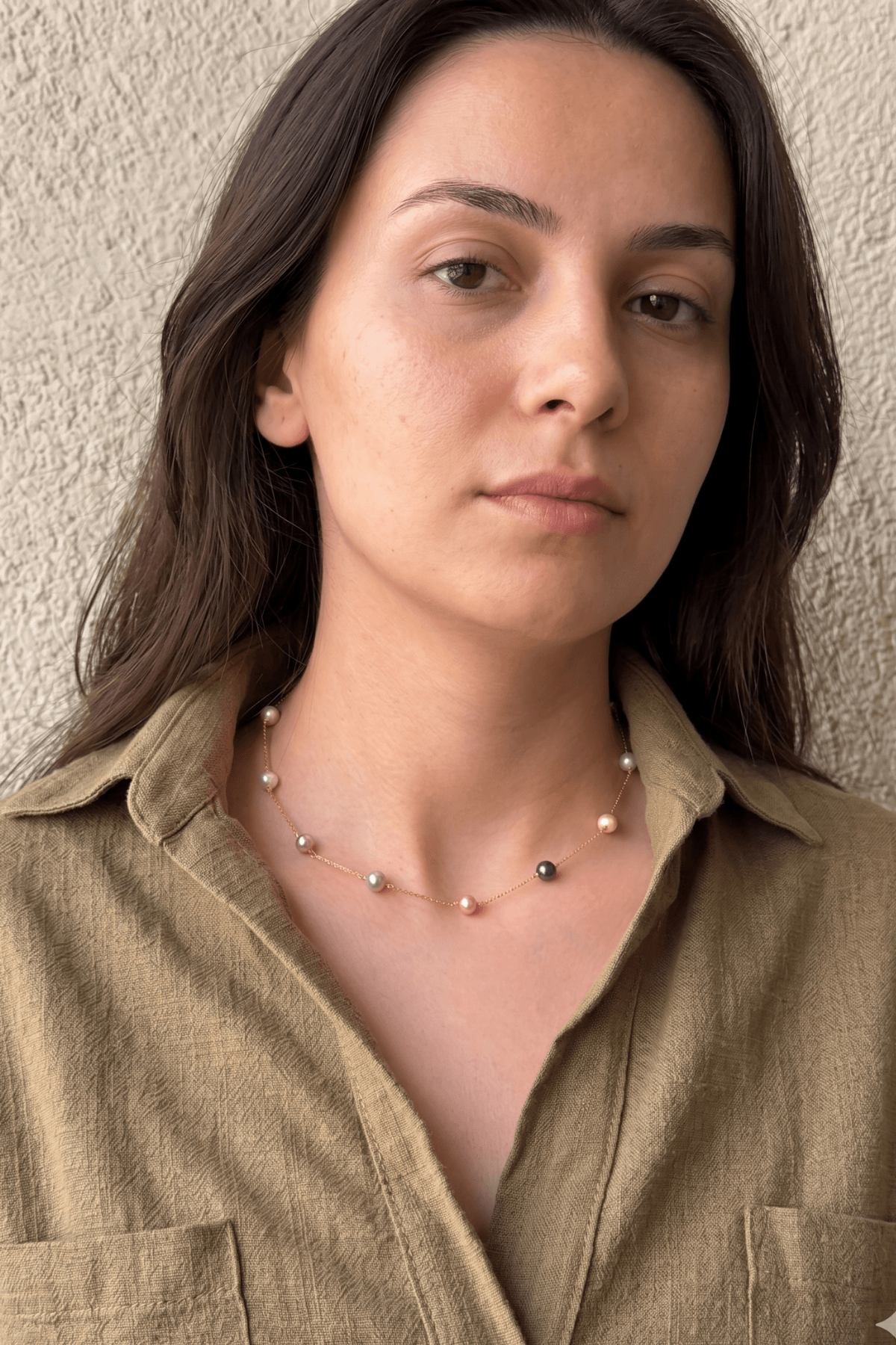 doğal inci kolye takan kadın modeli, 12 inci ile şık bir görünüm sunuyor.