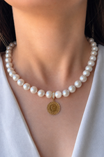 Doğal inci kolye üzerinde çeyrek altın detayı ile şık bir görünüm. Natural pearl necklace with quarter gold.