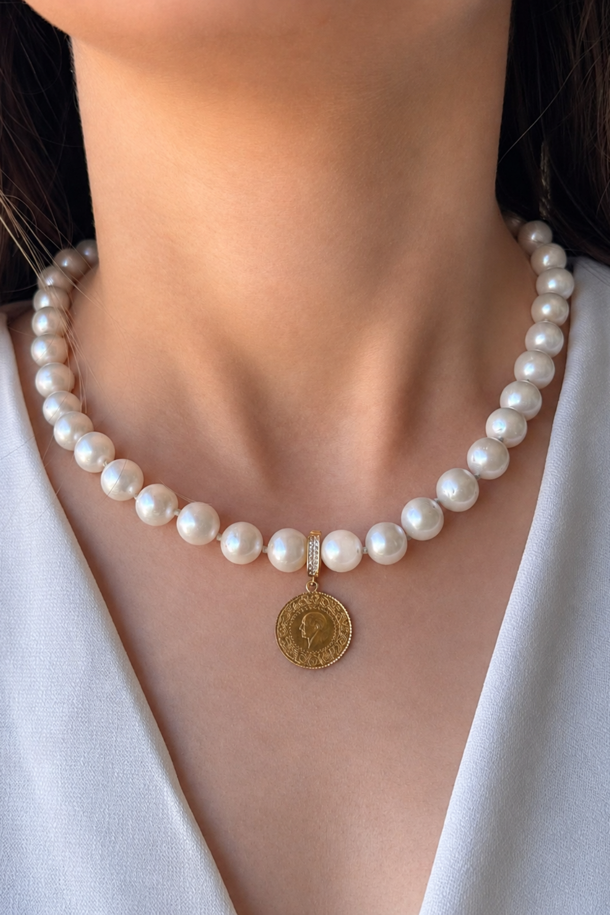 Doğal inci kolye üzerinde çeyrek altın detayı ile şık bir görünüm. Natural pearl necklace with quarter gold.