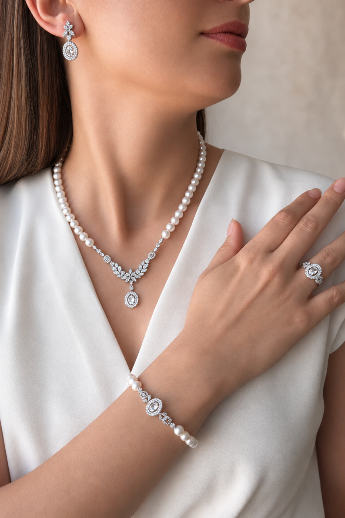 natural pearl jewelry set displayed on model with earrings, necklace, ring, and bracelet.