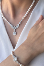 Natural pearl jewelry set showcased on a model, featuring a pearl necklace and bracelet with elegant design.