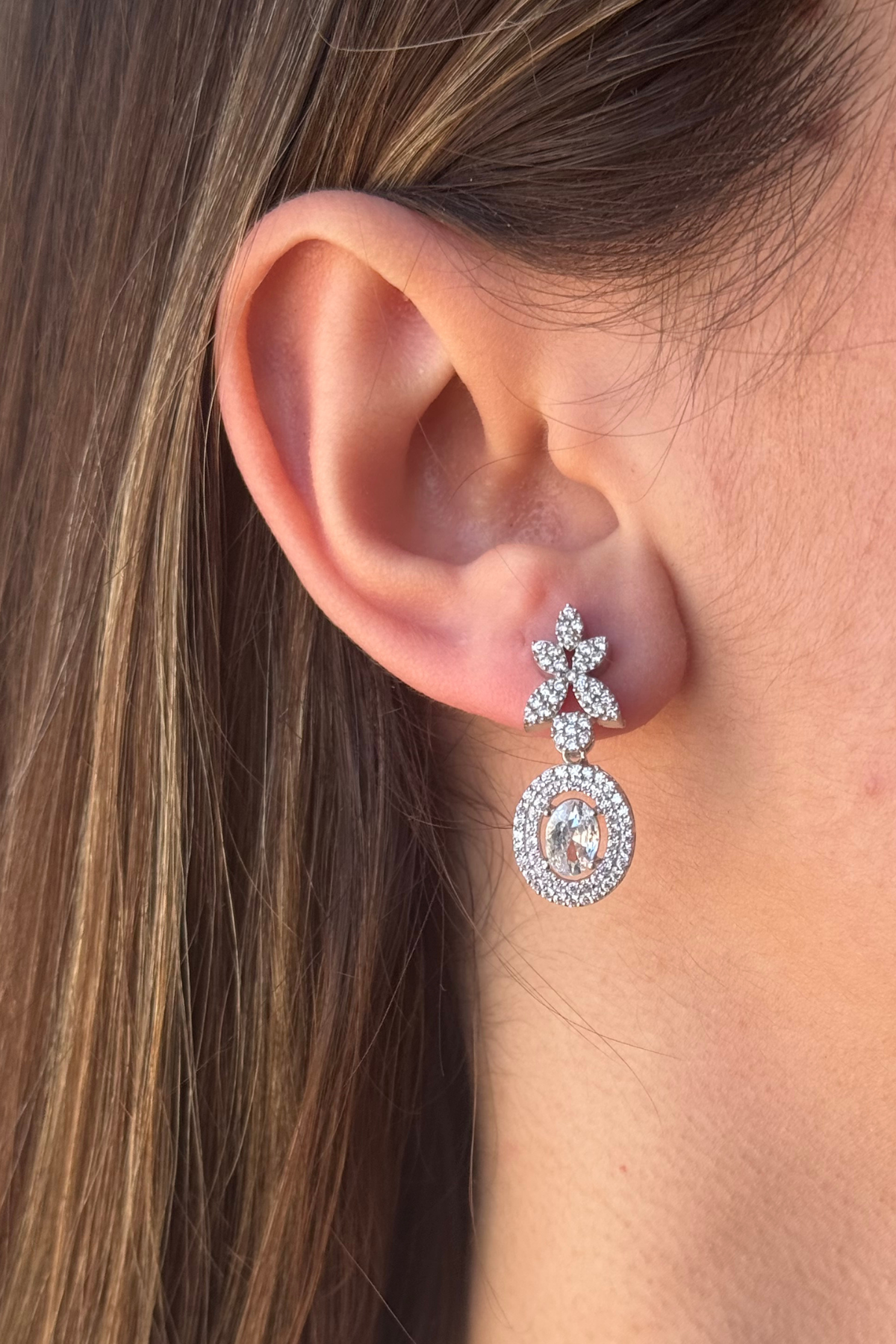 Natural pearl jewelry set featuring elegant earrings with sparkling design worn on the ear.