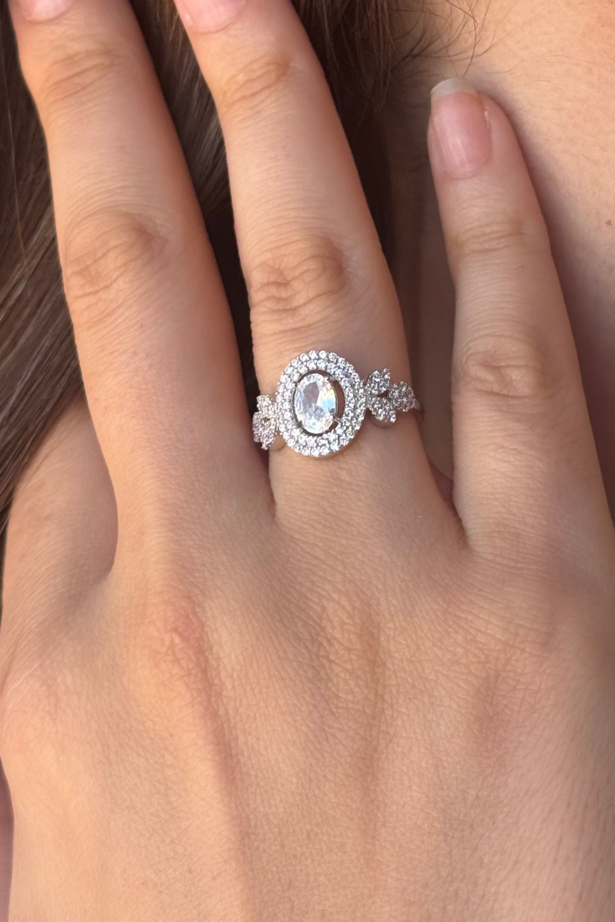A close-up of a hand wearing a sparkling ring, showcasing elegant natural pearl jewelry set design.