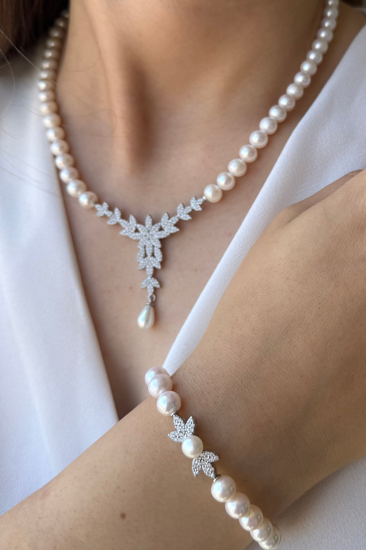 Natural pearl jewelry set featuring a necklace and bracelet, showcasing elegant design with pearls and diamonds.