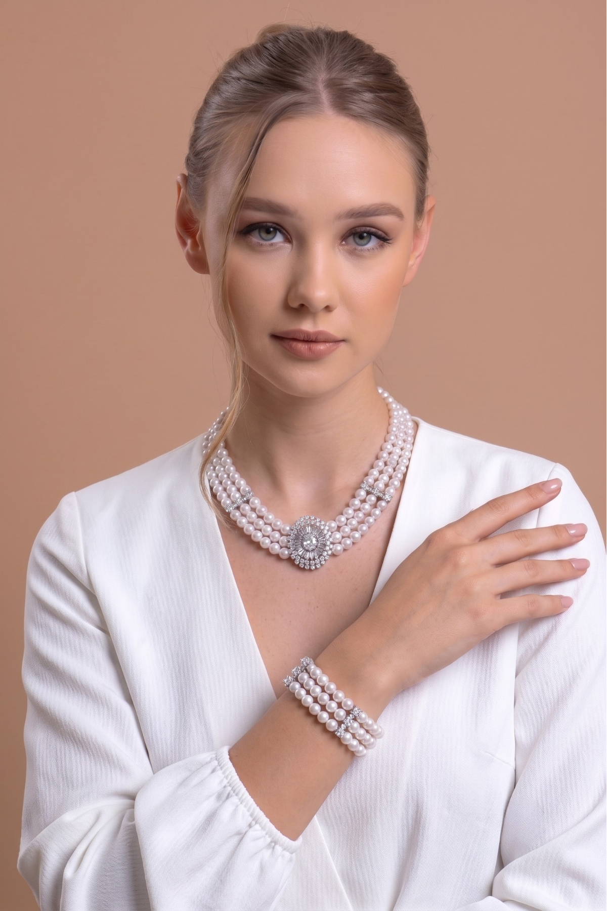 Model wearing Nadide Doğal İnci Set, showcasing natural pearl jewelry set in an elegant white outfit.