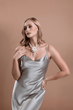 Barok Buketi Doğal İnci Kolye takmış bir kadın, şık gümüş elbise ile poz veriyor.